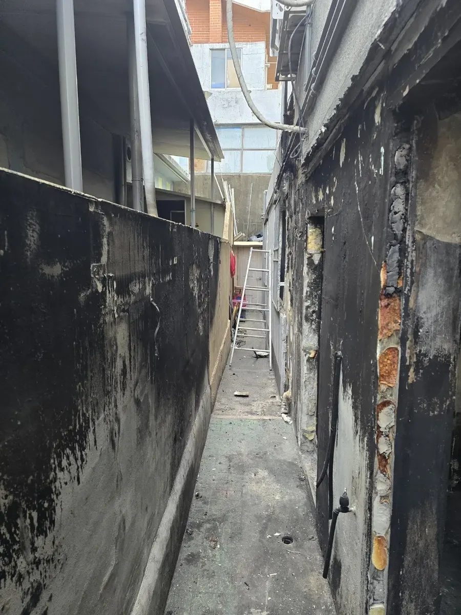 원룸화재복구청소 작업 중 오염된 벽면과 바닥을 세정하는 모습